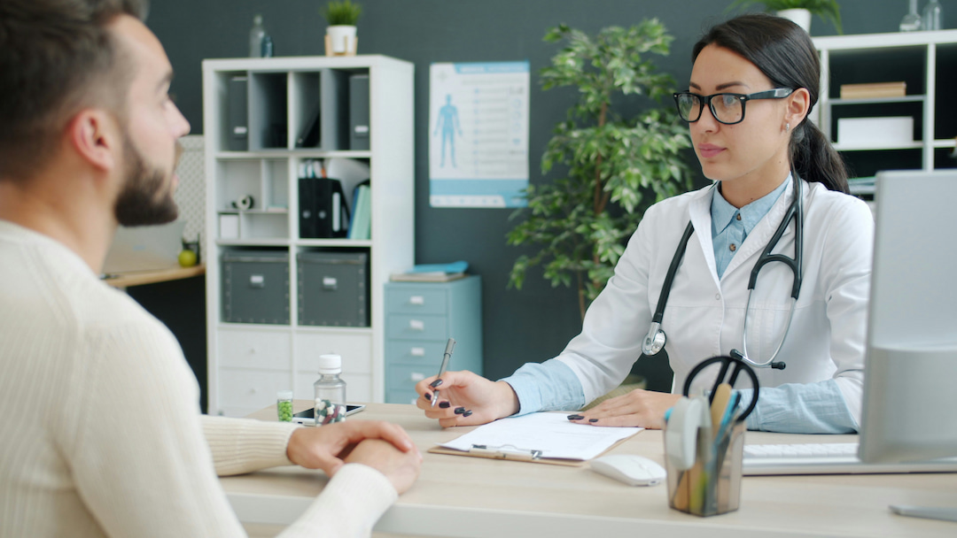 Clinical research setting showing a healthcare professional in conversation with a study participant, representing participant-centered care